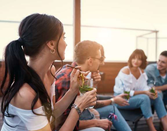 A group of people are sitting on a patio enjoying drinks.