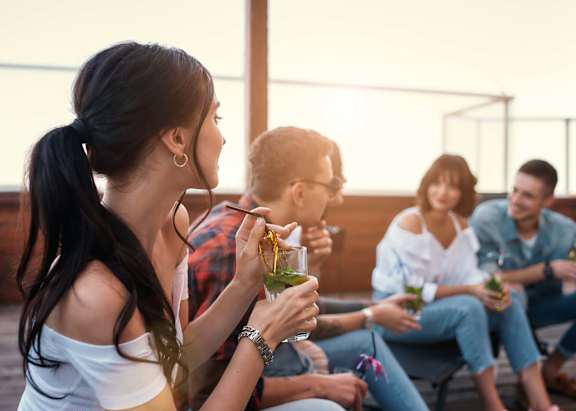 A group of people are sitting on a patio enjoying drinks.