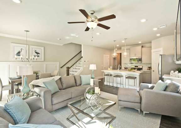 A modern open-plan living and dining area with a wooden table and green chairs.