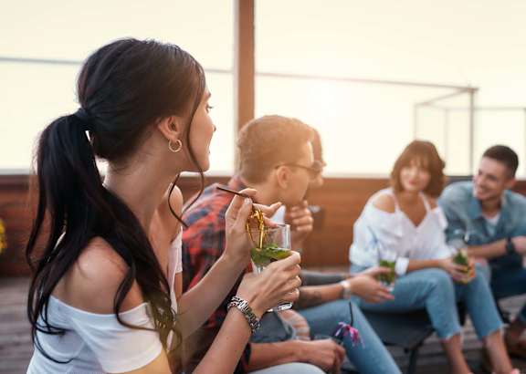 A group of people are sitting on a patio enjoying drinks.
