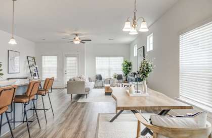a living and dining room area with white walls and hardwood flooring