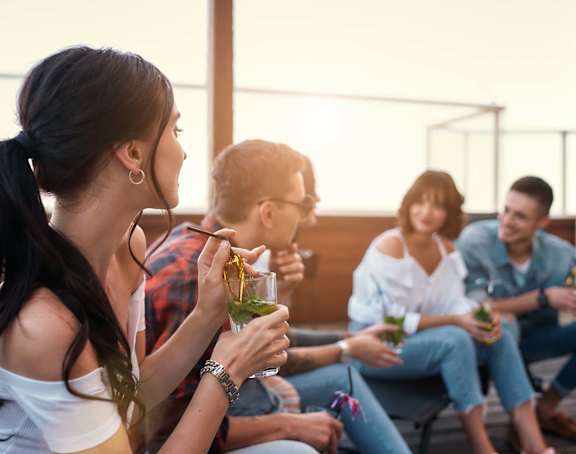 A group of people are sitting on a patio enjoying drinks.