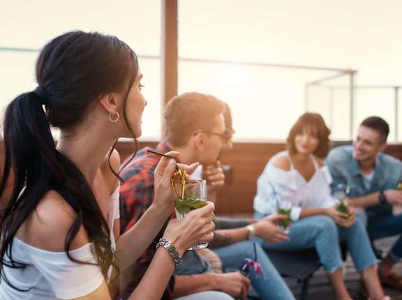 A group of people are sitting on a patio enjoying drinks.