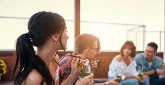 a group of people sitting around eating and drinking