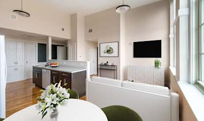 a kitchen and dining room with a white table and chairs at Beverly Village for Living & the Arts Apartments, Massachusetts, 01915