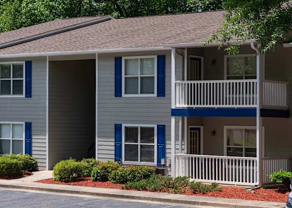 A two-story house with blue shutters and white railings.