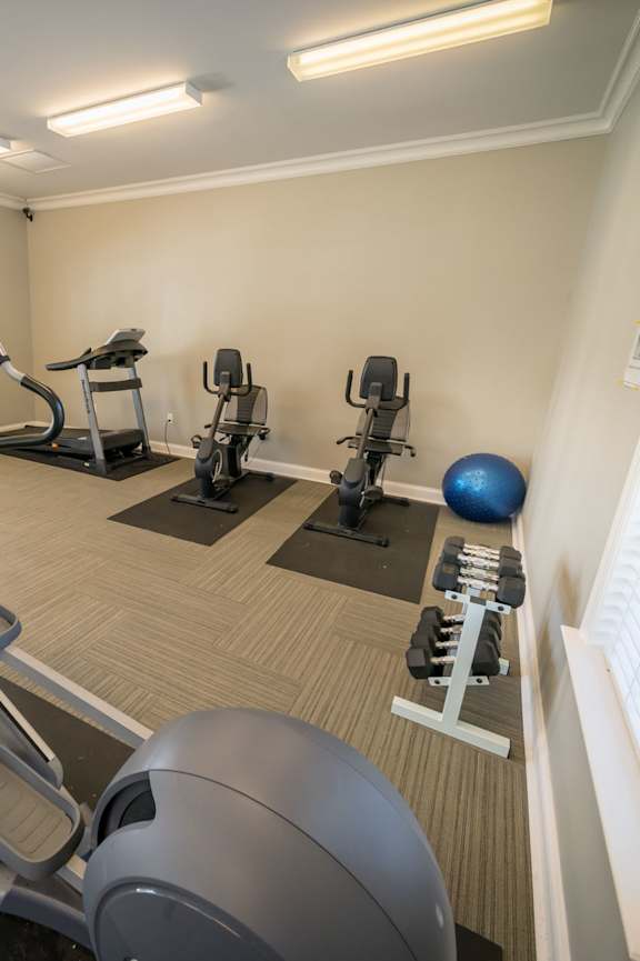 a fitness center with cardio equipment and weights in a gym