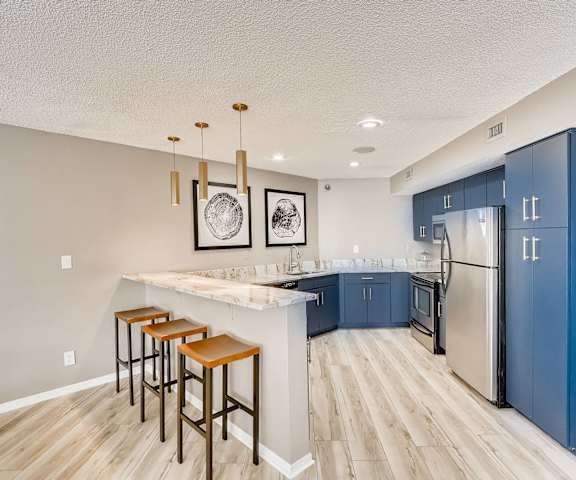 A kitchen with a bar area and blue cabinets.