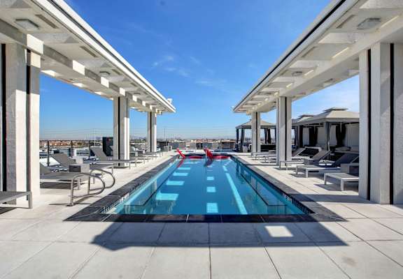 a pool on the roof of a building with a blue sky in the background