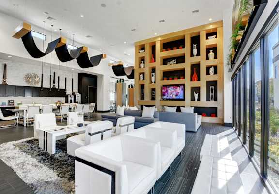 A large lounge area near the coffee bar with chairs and couches and glass window view