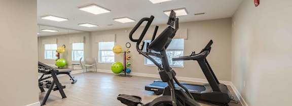 A spacious gym with a variety of exercise equipment including treadmills, elliptical machines, and stationary bikes.