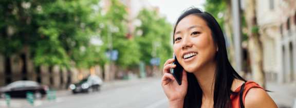 A woman is talking on her phone on a city street.