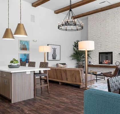 A modern living room with a kitchen area in the background.