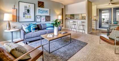 Model living room with a grey couch and a coffee table.