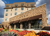 Thumbnail 2 of 11 - Exterior view of building with flowers surrounding entrance