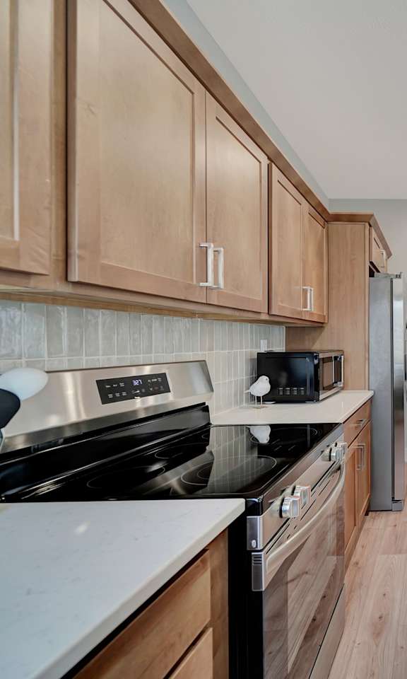 a large kitchen with wooden cabinets and white counter tops