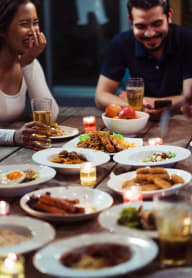 a group of people sitting around a table eating food