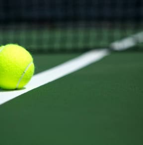 a tennis ball on a court with a racket