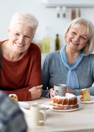 a group of people sitting around a table eating cake