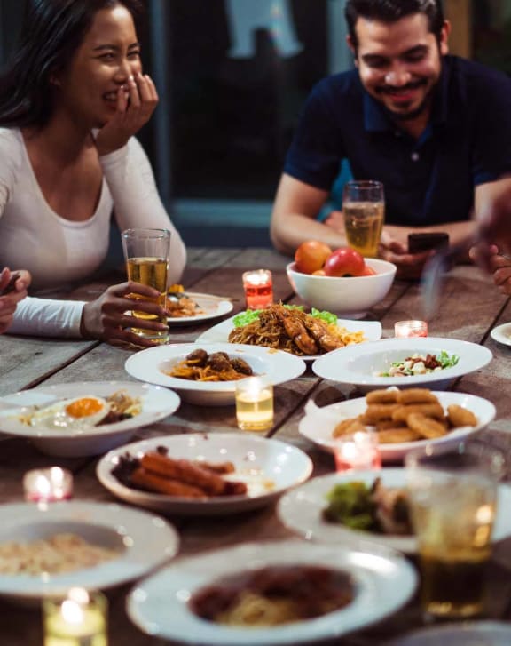 a group of people sitting around a table eating food