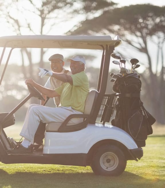 two men in a golf cart on a golf course