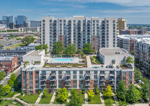 an aerial view of a building with a pool in the middle