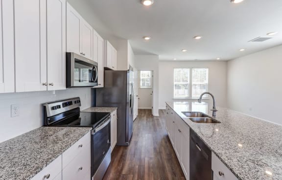 a kitchen with granite counter tops and black appliances