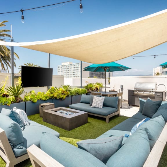a rendering of a rooftop patio with couches and umbrellas