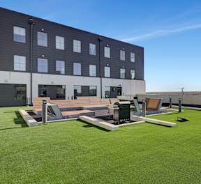 the rooftop patio on the fifth floor of a building with lawn and lounge furniture at Parkhaus Apartments,Nebraska 68508