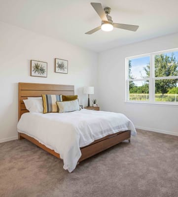 a bedroom with a bed and a ceiling fan
