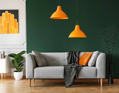 a living room with a couch and yellow lamps