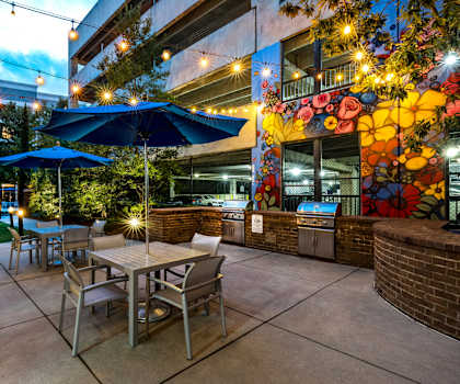 A patio with a table and chairs under umbrellas.