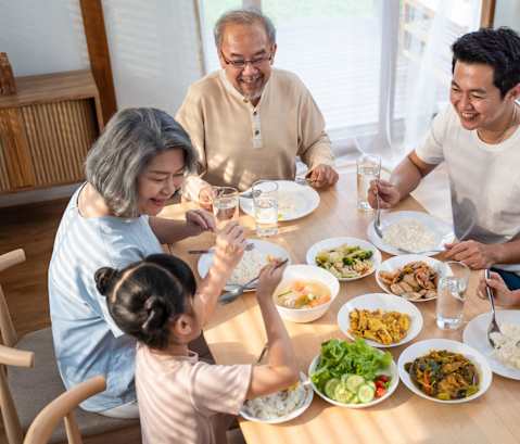 a group of people sitting around a table eating food