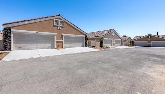 A row of houses with garages and driveways.