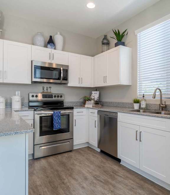 A modern kitchen with white cabinets and stainless steel appliances. at Vistoria At Marley Park Apartments, Arizona