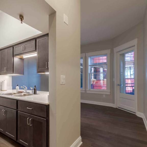 A kitchen with dark brown cabinets and a white countertop.
