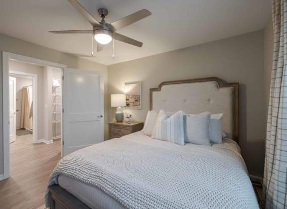 A bedroom with a large bed and a ceiling fan.