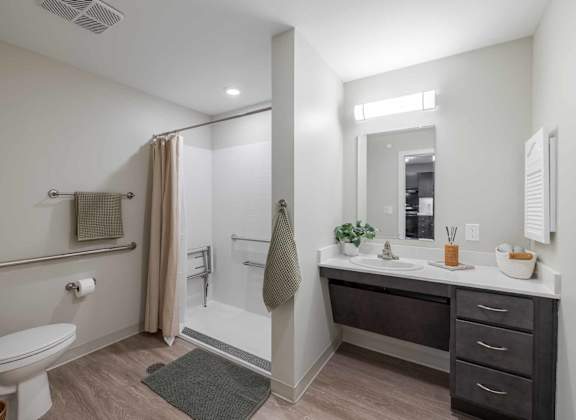 A bathroom with a toilet, sink, and shower.