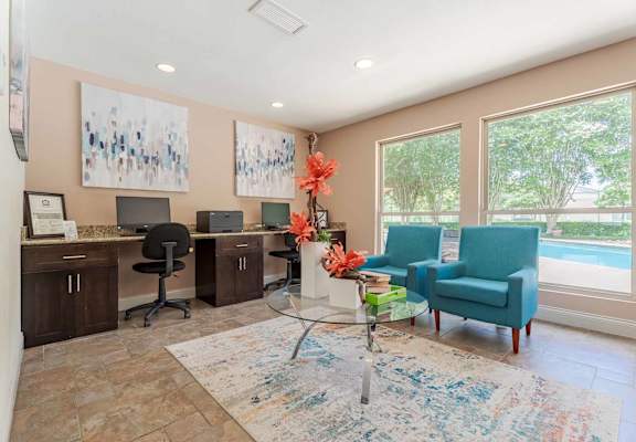 A room with a blue chair and a table with flowers on it.