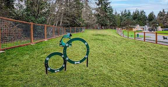 A playground with a green slide and orange fencing.