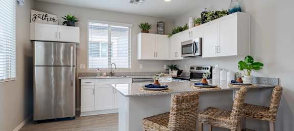 A kitchen with a refrigerator, sink, and countertop. at Vistoria At Stadium Apartments, Glendale, Arizona