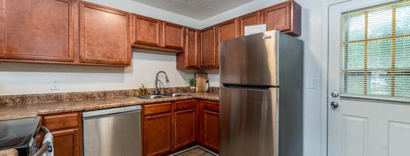 a kitchen with stainless steel appliances and wooden cabinets