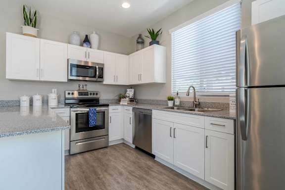 A kitchen with white cabinets and stainless steel appliances. at Vistoria At Marley Park Apartments, Arizona