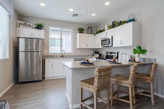 A kitchen with a refrigerator, sink, and countertop.
