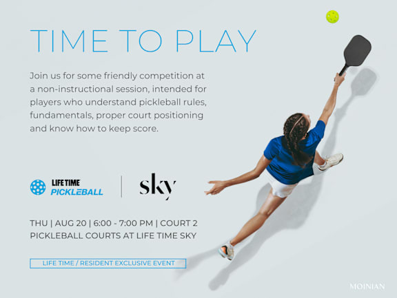 A woman playing pickleball with a ball in the air.