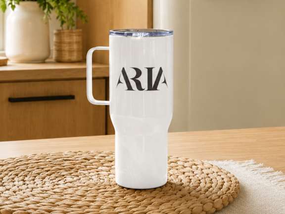 A white mug with the word Aria on it sits on a woven mat at Aria, New York, 10038.