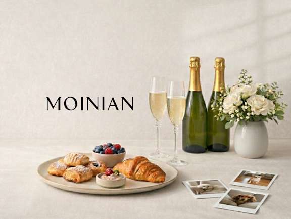 Two champagne bottles and a plate of food on a table at Aria, New York, 10038.