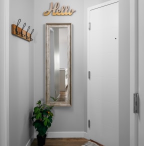 a hallway with a mirror and a plant