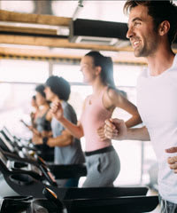 A group of people are running on treadmills in a gym.