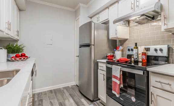 A kitchen with a stove top oven and a refrigerator.